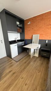 una piccola cucina con scrivania bianca e computer portatile di Flat Barra - Rio Centro a Rio de Janeiro