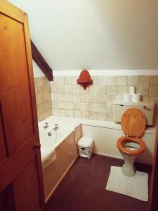 a bathroom with a toilet and a tub and a sink at Seaside Cottage in HAW
