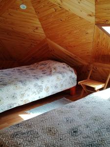 a bedroom with a bed in a wooden attic at Los Cipreses in Ancagual