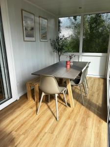 a dining room with a wooden table and chairs at Buurman aan zee in Julianadorp