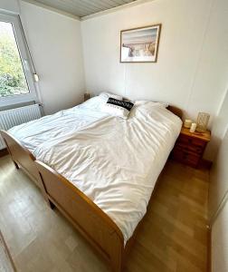 a large bed in a room with a window at Buurman aan zee in Julianadorp