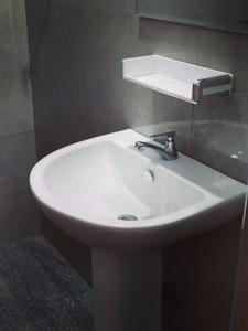a bathroom with a white sink and a mirror at WR Family and Holiday Resort in Anuradhapura