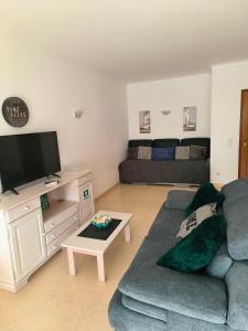 a living room with a couch and a flat screen tv at DUNAS DO ALVOR by LTS Holidays - #127 in Alvor +17 photos