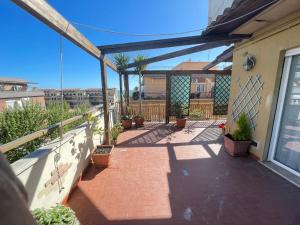 a patio with potted plants on a balcony at Le Palme in Lido di Ostia