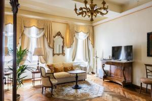 a living room with a couch and a tv at Palazzo Lari Sarzana - Historic Boutique Rooms in Sarzana