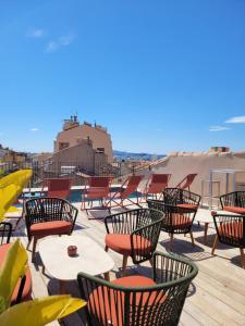 a bunch of chairs and tables on a roof at Grand Hôtel Dauphiné Toulon, Boutique Hôtel & Suites in Toulon