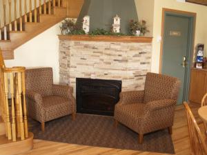 a living room with two chairs and a fireplace at Lakeview Inns & Suites - Brandon in Brandon