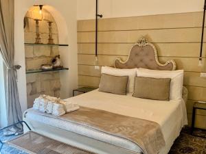a bedroom with a large bed with a large headboard at HABITARE Lecce & Salento in Lecce