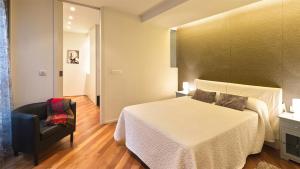 a hotel room with a bed and a chair at Casa Soto Del Ebro in Tudela