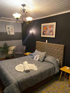 Un dormitorio con una cama con una lámpara y una silla. en Hotel Toesca, cercano a Movistar Arena, en Santiago