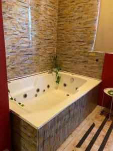 bañera grande en una habitación con pared de ladrillo en Hotel Toesca, cercano a Movistar Arena, en Santiago