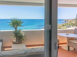 a room with a view of the ocean from a balcony at Bliss Luz Horizon - Panoramic Sea View - 50m to Beach - Central Praia da Luz - Walk distance to Everywhere in Luz