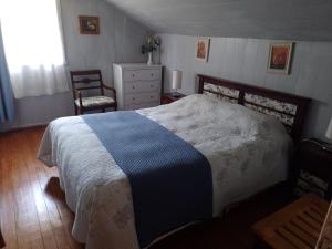 a bedroom with a large bed and a chair at La Posada del Colono in Puerto Clocker