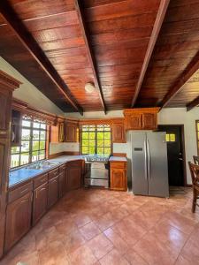 a kitchen with wooden cabinets and a stainless steel refrigerator at Come Enjoy Lakeside Bungalow in Gros Islet