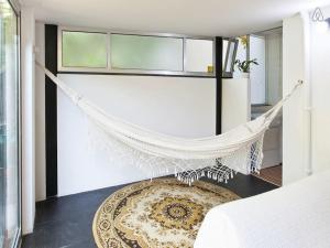 a hammock in a bedroom with a bed and a rug at Apartment with Private Garden in Porto