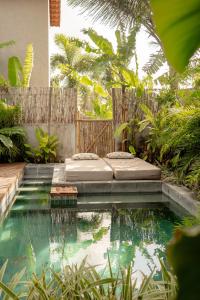 een zwembad met een bed in het midden van een tuin bij Casa Teçá in Guriú