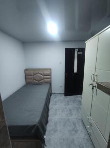 ein kleines Schlafzimmer mit einem Bett und einer schwarzen Tür in der Unterkunft Apartamento #3 in Puerto Colombia