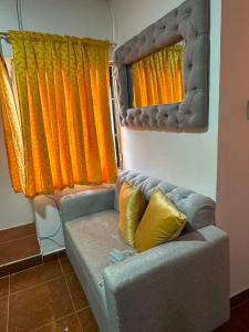 ein Sofa in einem Zimmer mit orangefarbenen und gelben Vorhängen in der Unterkunft Apartamento #3 in Puerto Colombia