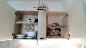 a kitchen with a shelf with plates and utensils at P I -G Ó 's HOUSE in Budoni +63 photos