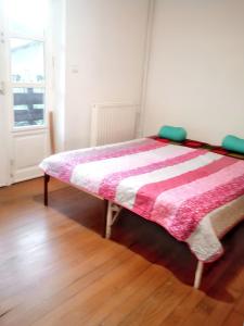 łóżko z różową i białą kołdrą w pokoju w obiekcie Maison charmante à Sainte-Agnés w mieście Sainte-Agnès +8 zdjęć