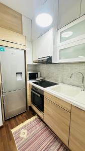 a kitchen with a sink and a refrigerator at Modern apartment in the heart of Tirana in Tirana