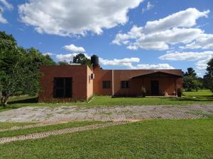 a small building with a grassy field in front of it at Casa Quinta Tambo in Garupá +27 photos