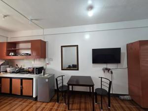 a kitchen with a table and a counter with a television at Andy's Place Studio in Legazpi