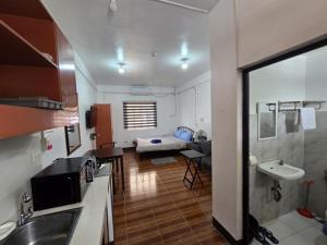 a kitchen with a sink and a room with a bed at Andy's Place Studio in Legazpi +3 photos