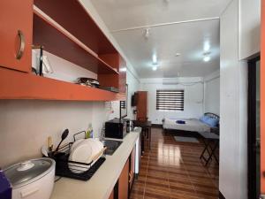 a kitchen with a counter and a room with a bed at Andy's Place Studio in Legazpi
