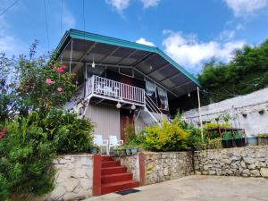 a house with a balcony and some plants at Townside Lodge in Nuwara Eliya