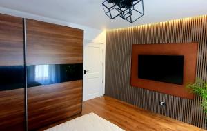 a living room with a tv and a wall at Central One Guesthouse in Reşiţa