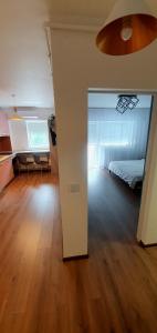 a bedroom with a bed and a room with a wooden floor at Central One Guesthouse in Reşiţa