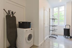 a laundry room with a washing machine and a window at Le Patio de l'Isle in Périgueux