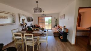 a dining room and living room with a table and chairs at Casa mediterranea vista al mar in Quintero