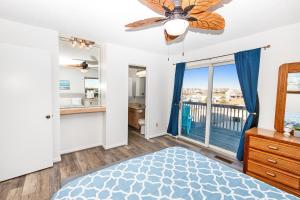 a bedroom with a bed and a ceiling fan at Oceanside, Close to Ocean, Grocery store and shopping! KD104, Cake by the Ocean in Kill Devil Hills