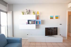 a living room with a tv on a white wall at Casa Adelaide in Senigallia