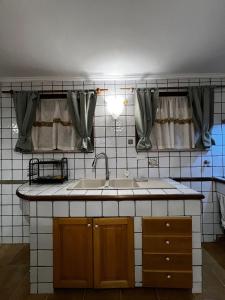 a kitchen with a sink and some curtains at LA MAISON aeroporto ciampino in Ciampino +23 photos