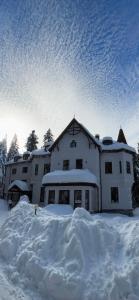 a building covered in snow with a pile of snow at Villa Ibar in Borovets