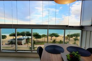 an office with a table and chairs and a large window at Condomínio à beira mar em Praia de Itaparica in Vila Velha