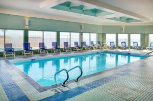 una gran piscina con sillas azules y ventanas en Lakeview Gimli Resort, en Gimli