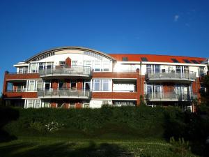 ドルム・ノイフェルトにあるFerienwohnung mit Nordseeblick! de Swolkのバルコニー付きの大きな建物