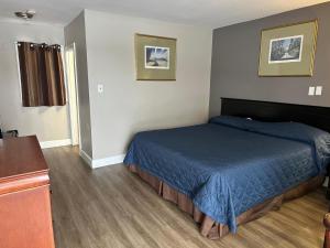 a bedroom with a bed with a blue blanket at Kitchener Motel in Kitchener
