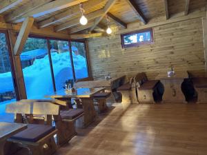 a restaurant with wooden tables and benches in a room at Villa Ibar in Borovets