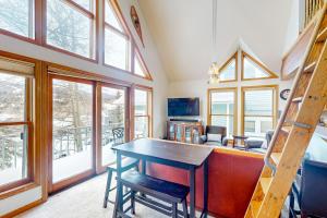 a dining room with a table and chairs and windows at Silver Jacks Condo in Breckenridge