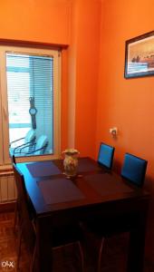 a dining room table with chairs and a window at Apartman Aylin 2 in Tuzla