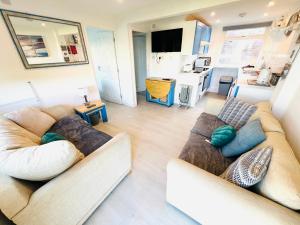 a living room with two couches and a kitchen at 2 Bedroom Chalet SB88, Sandown, Isle of Wight, Dog Friendly in Sandown