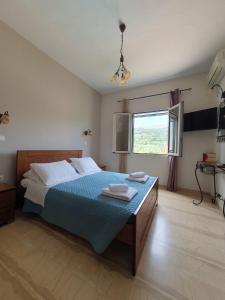 a bedroom with a bed with two towels on it at Emily's Apartments in Kassiopi