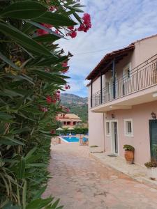 a view of a house and a yard with flowers at Emily's Apartments in Kassiopi