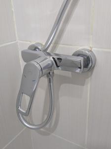 un cabezal de ducha en la pared del baño en Компактная студия в центре, en Chişinău