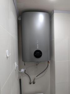 Un tanque de agua en la pared de un baño. en Компактная студия в центре, en Chişinău